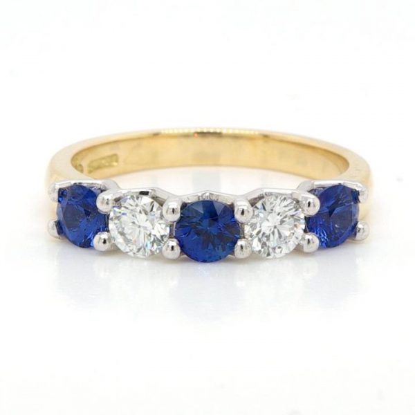 Sapphire and Diamond Five Stone Ring; featuring three round faceted sapphires alternated with two round brilliant-cut diamonds. Mounted in platinum on an 18ct yellow gold shank