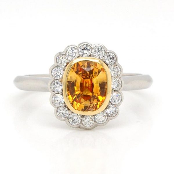 Cushion Cut Orange Sapphire and Diamond Cluster Ring; beautiful and unusual 1.29 carat orange cushion cut sapphire set in yellow gold within a surround of 0.34cts collet-set diamonds, to a plain platinum shank