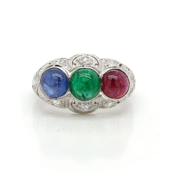 Cabochon Emerald, Ruby and Sapphire Three Stone Ring; mounted in an ornate Edwardian diamond-set pierced platinum mount. Mount Circa 1915