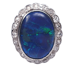Vintage Black Opal and Old Cut Diamond Oval Cluster Dress Ring; featuring a large oval black opal surrounded by 0.60cts circular old-cut diamonds. Mounted in 18ct white gold. English, Circa 1940s