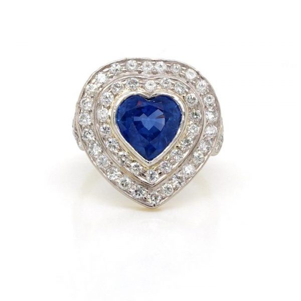 Vintage Heart Cut Sapphire and Diamond Cluster Ring; central 3.31ct heart shaped faceted blue sapphire within a double surround of 0.85cts brilliant cut diamonds