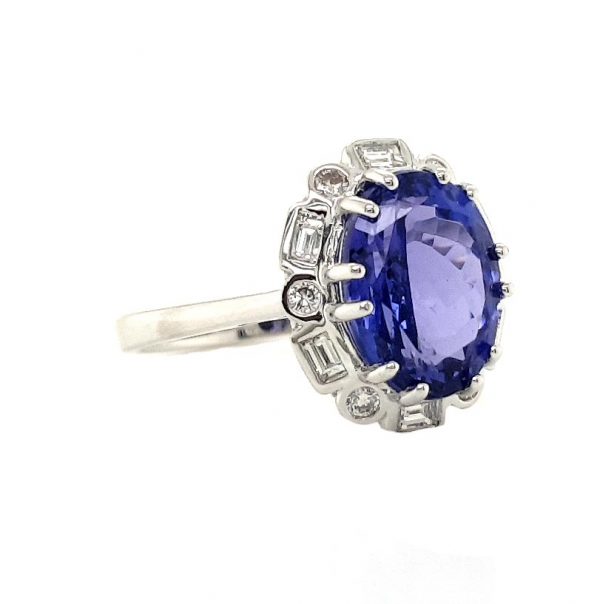 Tanzanite and Diamond Cluster Dress Ring; central 4.56 carat oval faceted tanzanite with brilliant and baguette-cut diamond surround, in 18ct white gold