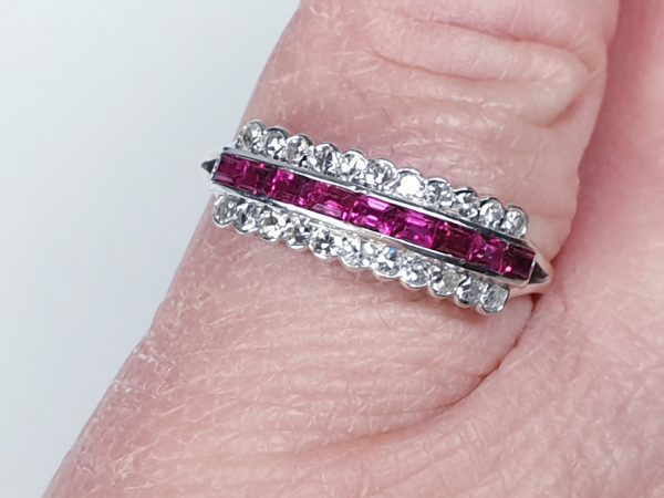 Art Deco Ruby and Diamond Half Hoop Eternity Ring; central band of 0.20cts calibre-cut rubies with a row of brilliant-cut diamonds either side, in rubover settings in platinum. Circa 1920