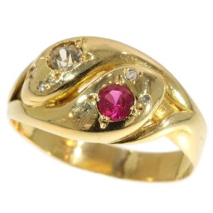 An antique gold double headed snake ring set with a ruby and diamond to each head and diamond set eyes. Mounted in 18ct gold.  