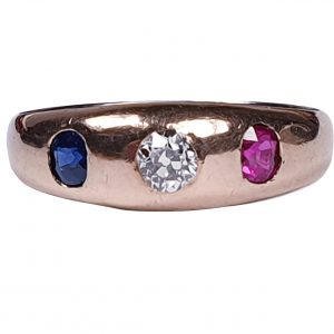 Antique Victorian Diamond, Sapphire and Ruby Three Stone Ring; central 0.33ct cushion cut diamond with 0.25ct ruby one side and 0.25ct sapphire the other side, in gold. English, Circa 1880