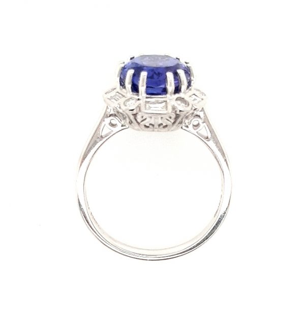 Tanzanite and Diamond Cluster Dress Ring; central 4.56 carat oval faceted tanzanite with brilliant and baguette-cut diamond surround, in 18ct white gold