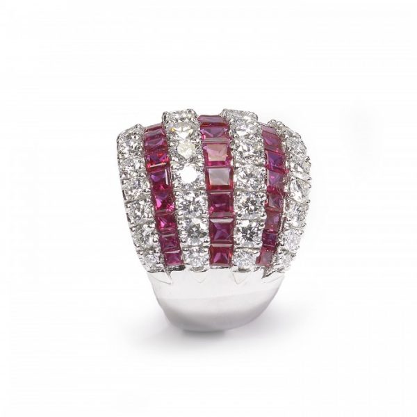 Contemporary Ruby and Diamond Bombe Cocktail Ring; seven alternating rows of 3.50cts calibre-cut rubies and 2.50cts round brilliant cut diamonds, claw and channel set in 18ct white gold, Circa 1990