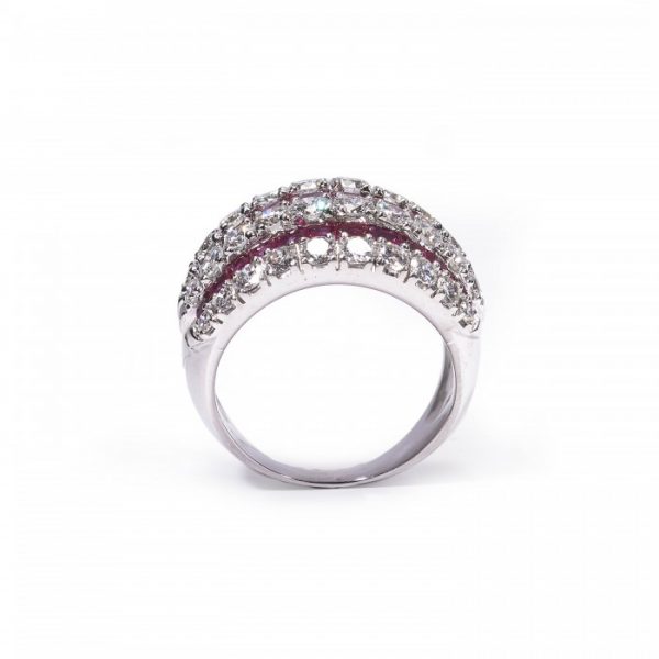 Contemporary Ruby and Diamond Bombe Cocktail Ring; seven alternating rows of 3.50cts calibre-cut rubies and 2.50cts round brilliant cut diamonds, claw and channel set in 18ct white gold, Circa 1990