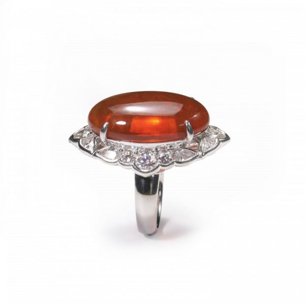 Cabochon Fire Opal and Diamond Cluster Ring in Platinum; central 18.00 carat oval shaped cabochon-cut fire opal, surrounded by 2.40cts brilliant and pear-cut diamonds