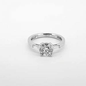 1.16ct Diamond Solitaire Engagement Ring with Baguette Diamond Shoulders; featuring a 1.16 carat round brilliant cut diamond, four-claw set in platinum, flanked by two tapered baguette diamonds on the shoulders