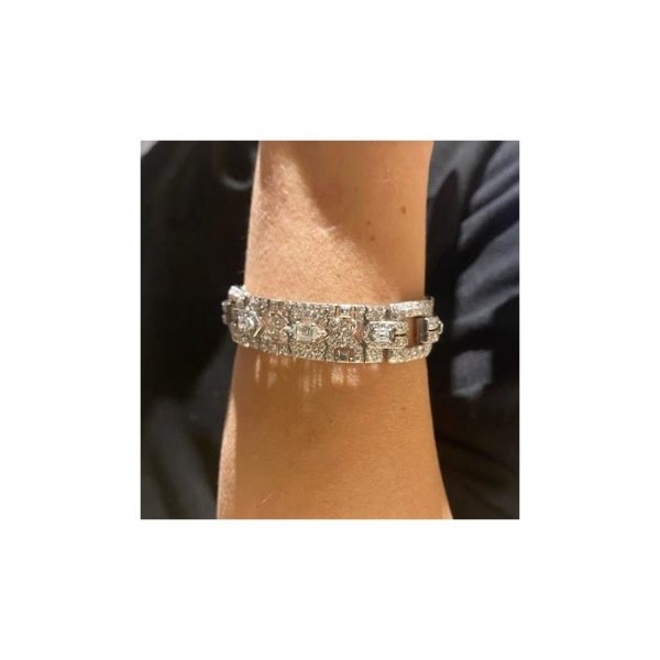 Vintage Cartier Diamond Bracelet; comprised of three panels, each set with a central trap-cut diamond flanked by triangular and fancy-cut diamonds, accented with transitional brilliant-cut and single-cut diamond set surrounds, 18.70 carat total. Mounted in platinum. Circa 1930