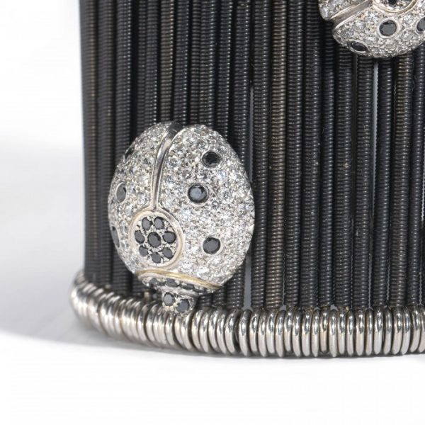 Diamond Butterfly and Ladybird Cuff Bracelet, set with 9.00 carats of black and white diamonds on anodised white gold twisted bars on sprung fittings