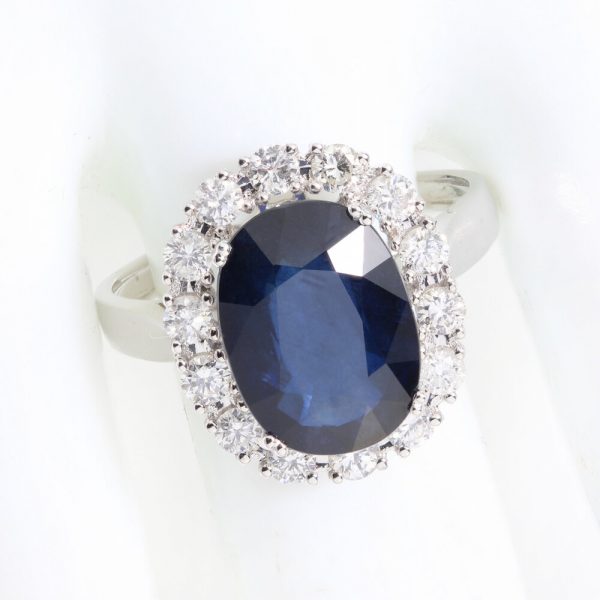 Vintage 1970s Sapphire and Diamond Oval Cluster Ring; 3.50ct oval faceted sapphire surrounded by 0.56cts brilliant-cut diamonds, 18ct white gold