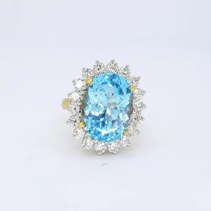 Blue Topaz and Diamond Oval Cluster Ring; 14.00 carat oval faceted blue topaz surrounded by 1.80cts brilliant cut diamonds, claw set in 18ct gold