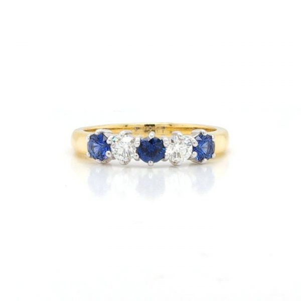 Sapphire and Diamond Five Stone Ring; featuring three round faceted sapphires and two round brilliant-cut diamonds, claw set, to an 18ct yellow gold band
