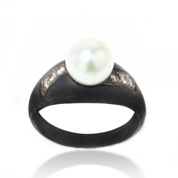 March and Co Vintage Pearl, Diamond and Gun Metal Ring; central 3 carat cultured pearl flanked by 0.12cts diamonds, Circa 1930s