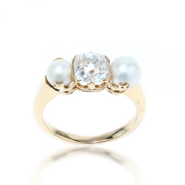 Antique Victorian Old Cushion Cut Diamond and Pearl Three Stone Ring; central 1.00 carat old cushion cut diamond flanked by two natural freshwater pearls, in 15ct yellow gold. Made in England, Circa 1890s