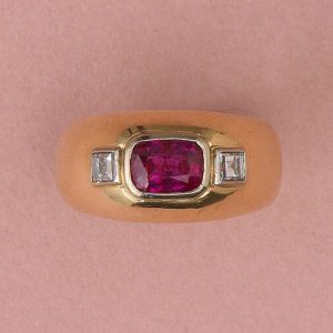Vintage French Ruby and Diamond Three Stone Dress Ring in 18ct Yellow Gold; 1.68ct table cut unheated ruby flanked by carré cut diamonds, Circa 1950s-1970s
