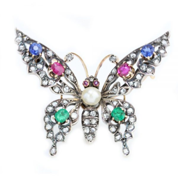 Antique Victorian Multi Gemstone Butterfly Brooch with Natural Pearl; natural freshwater pearl set within a rose-cut diamond encrusted body, accented with blue sapphires, rubies and emeralds. Set in silver and 15ct gold. Made in England, Circa 1860s