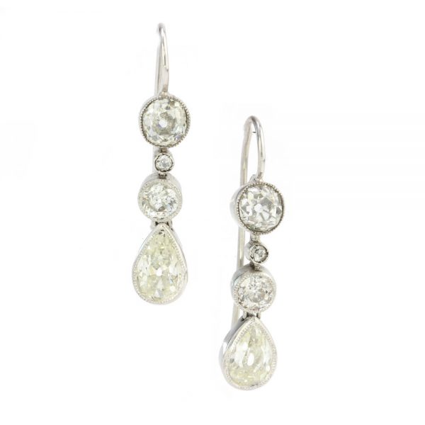 Antique Edwardian Old Cut Diamond Drop Earrings in Platinum; featuring pear-shaped diamonds suspended from three round old cut diamonds, Circa 1910
