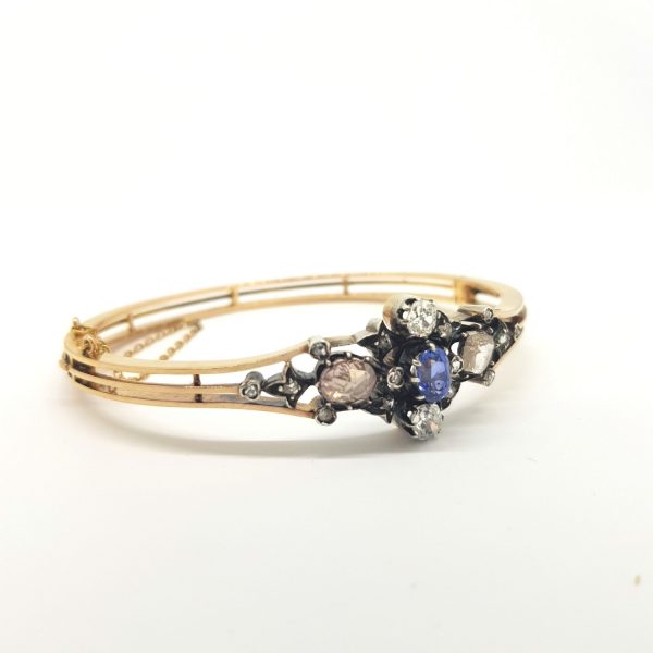 Antique Victorian Natural Sapphire and Diamond Bangle Bracelet; open band bangle set with a central natural sapphire, two white old-cut diamonds and two foiled pink rose cut diamonds