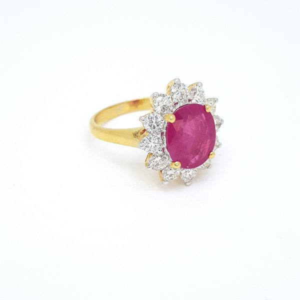 Ruby and Diamond Cluster Ring; central 3.05ct oval faceted ruby surrounded by 1.24cts brilliant-cut diamonds, in 18ct yellow gold