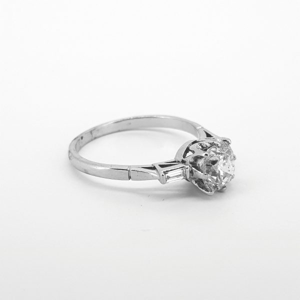 Old Cut Diamond Solitaire Engagement Ring; 1.41 carat old cut diamond, eight-claw set in a crown collet, accented with an open side set baguette-cut diamond to each shoulder, in 18ct white gold