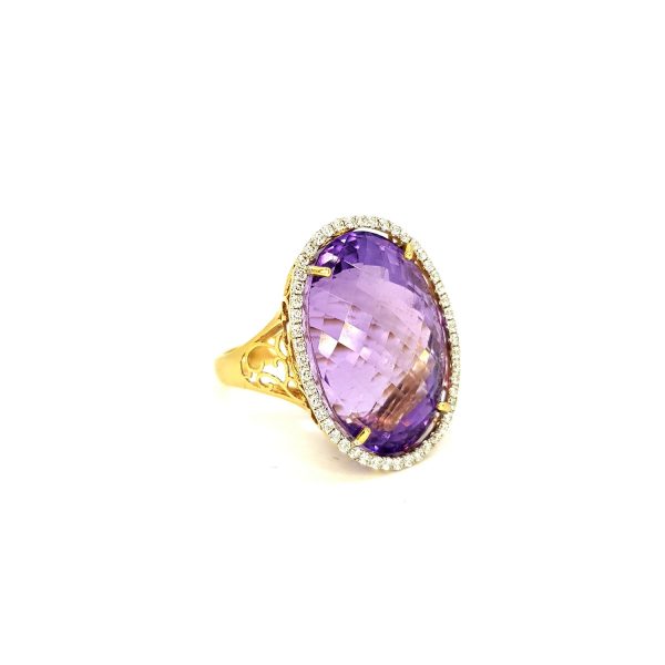 Amethyst and Diamond Oval Cluster Ring; featuring a large 30.00 carat oval faceted amethyst set within a diamond surround, in 14ct yellow gold with an openwork scrolled under-gallery