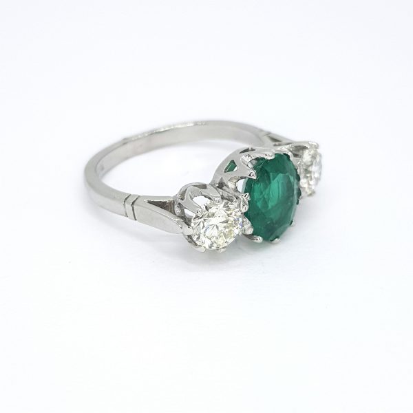 Emerald and Diamond Three Stone Ring in Platinum; central 1.73ct oval faceted emerald flanked by 1.05cts diamonds
