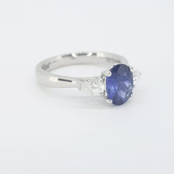 Sapphire and Pear Cut Diamond Trilogy Ring in Platinum; central 1.44ct Madagascan oval faceted sapphire flanked by 0.30cts pear-cut diamonds, claw set in platinum