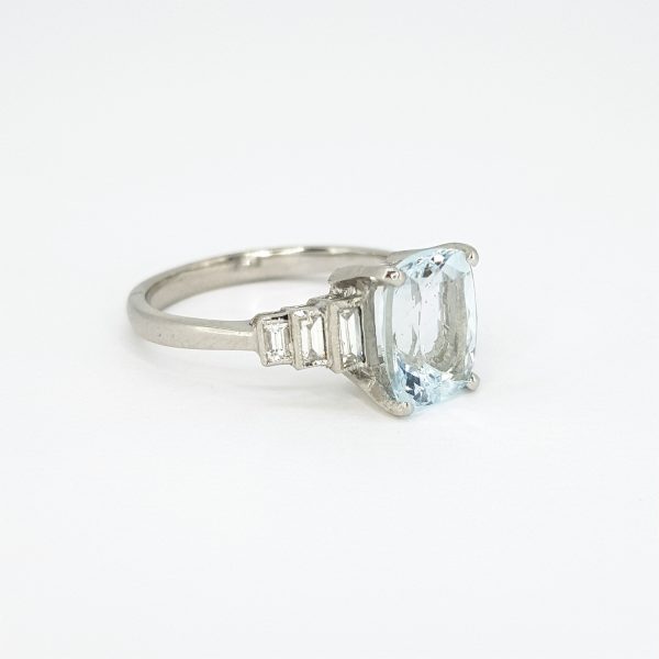 Art Deco Style Aquamarine and Diamond Ring in Platinum; 2.10ct cushion-shaped aquamarine with three graduated stepped baguette-cut diamonds to each shoulder