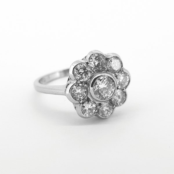 Daisy Flower Diamond Cluster Ring; comprised of nine brilliant-cut diamonds in a rubover setting and mounted in 18ct white gold, 1.50 carat total