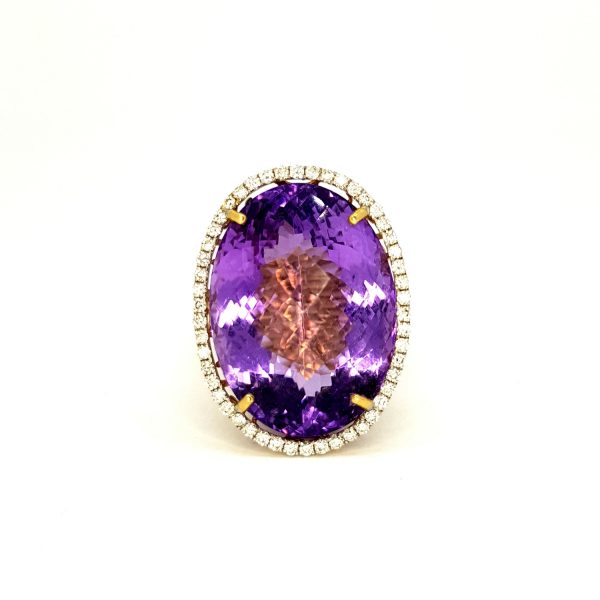 Amethyst and Diamond Oval Cluster Ring; featuring a large 30.00 carat oval faceted amethyst set within a diamond surround, in 14ct yellow gold