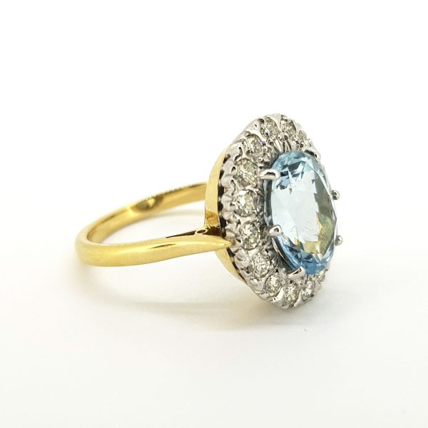 Aquamarine and Diamond Oval Cluster Ring; central 6.50 carat oval faceted aquamarine surrounded by 0.90cts diamonds, in 18ct gold