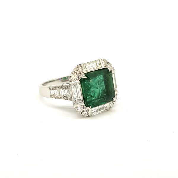 Emerald and Diamond Square Cluster Ring; central 4.22 carat square-cut emerald surrounded by 1.45cts brilliant and baguette-cut diamonds, in 18ct white gold