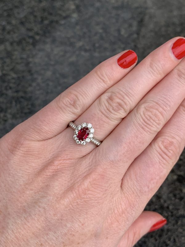 Ruby diamond engagement ring cluster oval 1 carat platinum on finger model