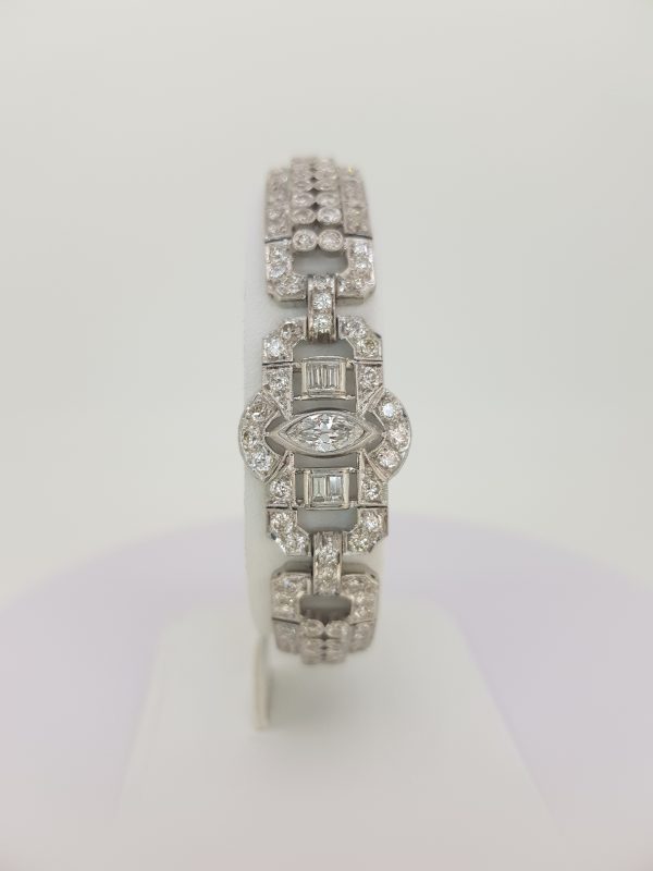 Vintage Geometric Diamond Bracelet in Platinum; central marquise cut diamond set within an open panel border decorated with baguette-cut and round brilliant-cut diamonds, Circa 1960s.