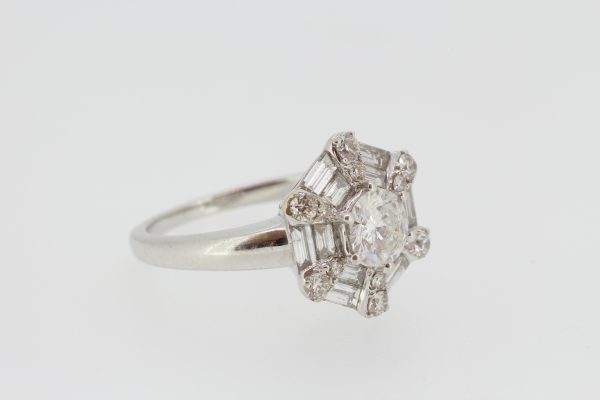 Contemporary Diamond Cluster Ring; central round brilliant-cut diamond surrounded by two rows of baguette cut diamonds to form a hexagonal design, accented with brilliant-cut diamonds at each corner, in 18ct white gold