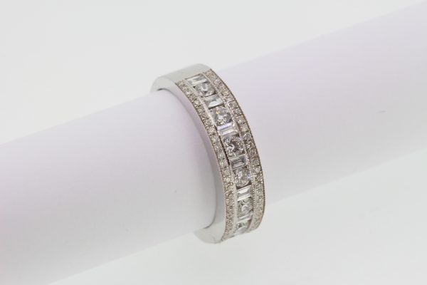 Channel Set Diamond Ring; channel set brilliant and baguette-cut diamonds flanked by rows of pave-set diamonds, 1.00 carat total, in 18ct white gold