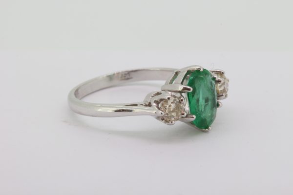 Emerald and Diamond Three Stone Ring; featuring a 1.45ct oval faceted emerald flanked by 0.65cts brilliant cut diamonds, in 18ct white gold