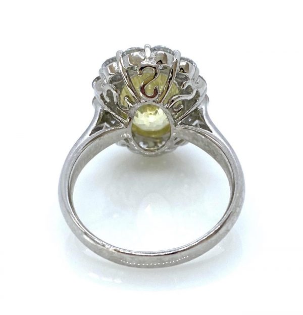 Yellow Sapphire and Diamond Oval Cluster Ring; 6.42ct Sri Lankan oval yellow sapphire with no heat treatment surrounded by 1.16cts diamonds, in 18ct white gold