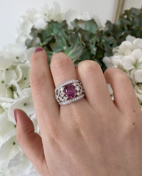 3.19ct Padparadscha Sapphire and Diamond Dress Ring by David Jerome; the central, unheated 3.19 carat oval faceted padparadscha sapphire is nestled upon a wide floral openwork band set with 1.56 carats of sparkling white diamonds, in 18ct white gold
