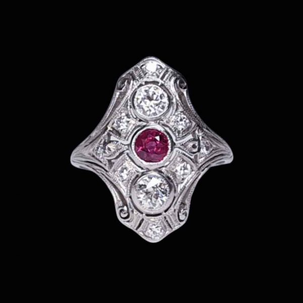 Antique Ruby and Diamond Plaque Dress Ring in Platinum; central 0.33ct ruby with a principal diamond above and below, set in a diamond-set openwork scroll design, 0.90cts total, Circa 1890