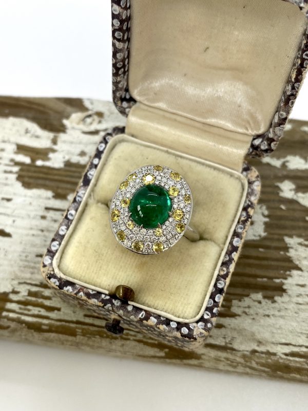 Cabochon Emerald and Diamond Cluster Ring in Platinum; 3.62ct cabochon-cut emerald with no oil within an oval white diamond and yellow sapphire surround