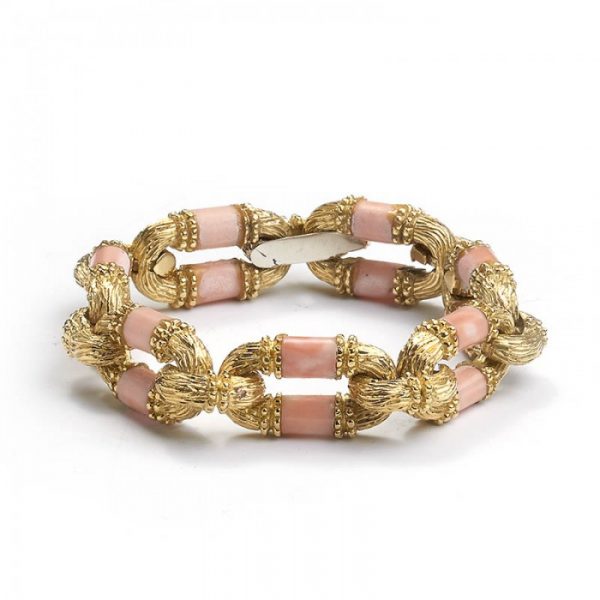 Vintage Coral and Gold Link Bracelet; seven oval links set with cylindrical coral bars in a gold bark effect link with beading detail, in 18ct yellow gold, Circa 1970s