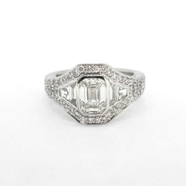 Contemporary Emerald Cut Diamond Cluster Ring; central GIA certified 1.22ct emerald-cut diamond is surrounded by brilliant and baguette-cut diamonds, in 18ct white gold, F colour, SI1 clarity