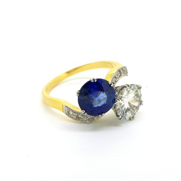 Sapphire and Diamond Toi et Moi Crossover Ring; featuring a 2.10ct sapphire and 1.54ct diamond entwined with a ribbon of pave set diamonds, in 18ct gold