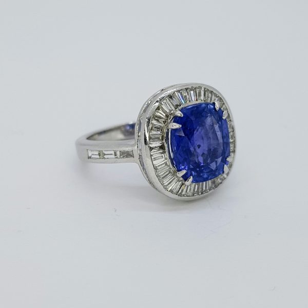 Ceylon Sapphire and Baguette Diamond Cluster Ring; featuring a fine 5.17ct Ceylon sapphire set within a halo of 2cts baguette diamonds, in 18ct white gold