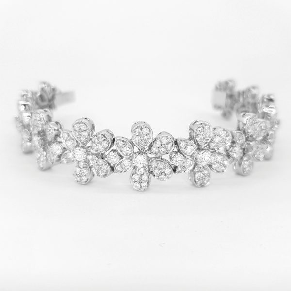 Contemporary Diamond Daisy Cluster Bracelet; comprised of 8 carats of pave set diamond floral clusters, push diamond clasp and 'D' clip safety catch, in 18ct white gold
