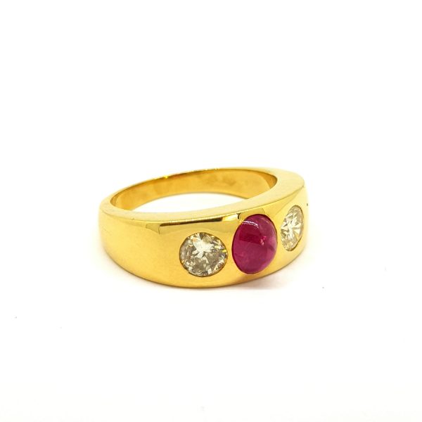 Cabochon Ruby and Diamond Gents Three Stone Ring; central cabochon-cut ruby flanked by diamonds, in a wide 18ct yellow gold band